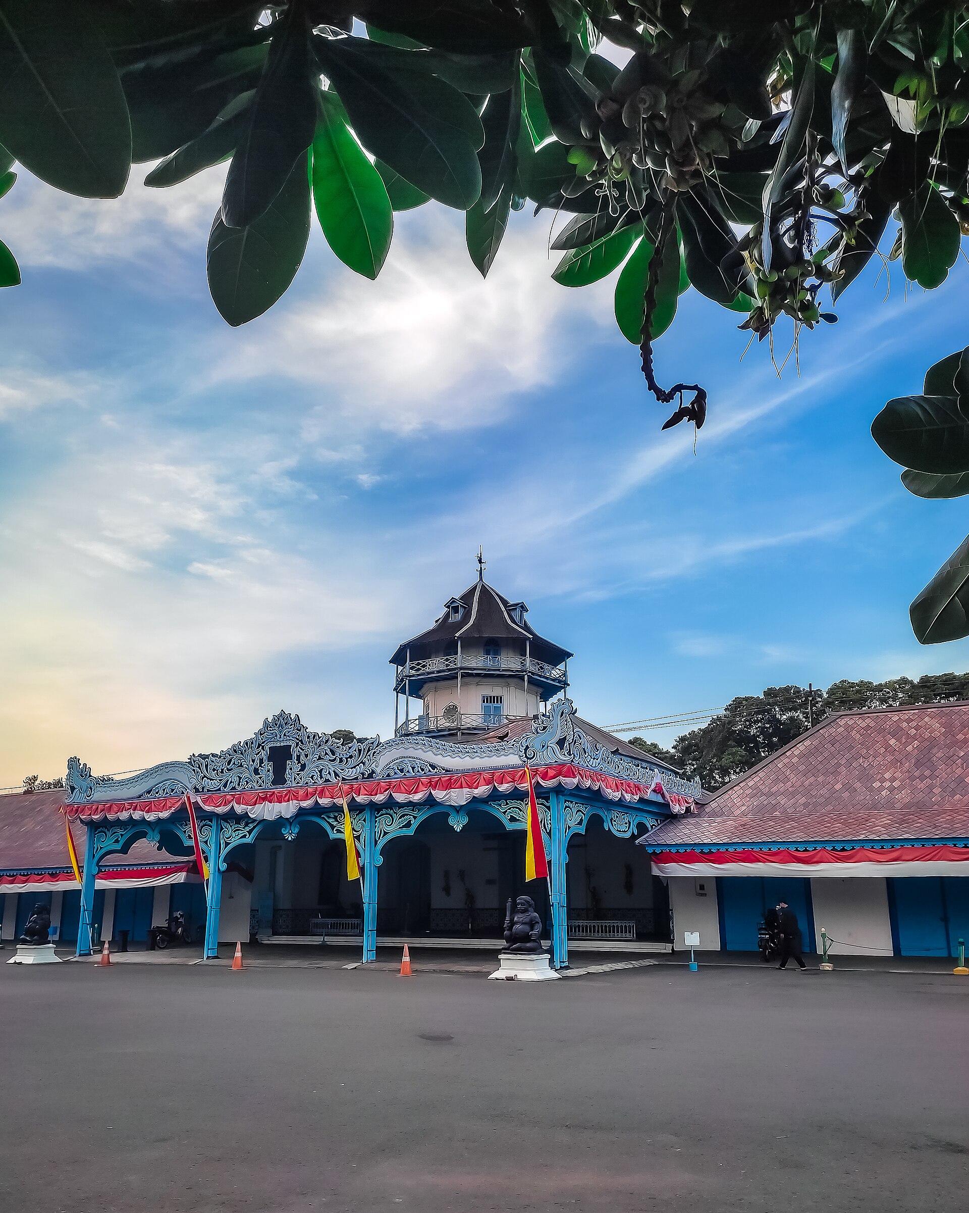 Bangunan Keraton Kasunanan Surakarta berwarna biru dan merah di bawah langit cerah